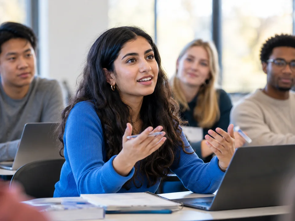 Illustrative classroom scene: a young adult learner participating in a discussion with classmates.